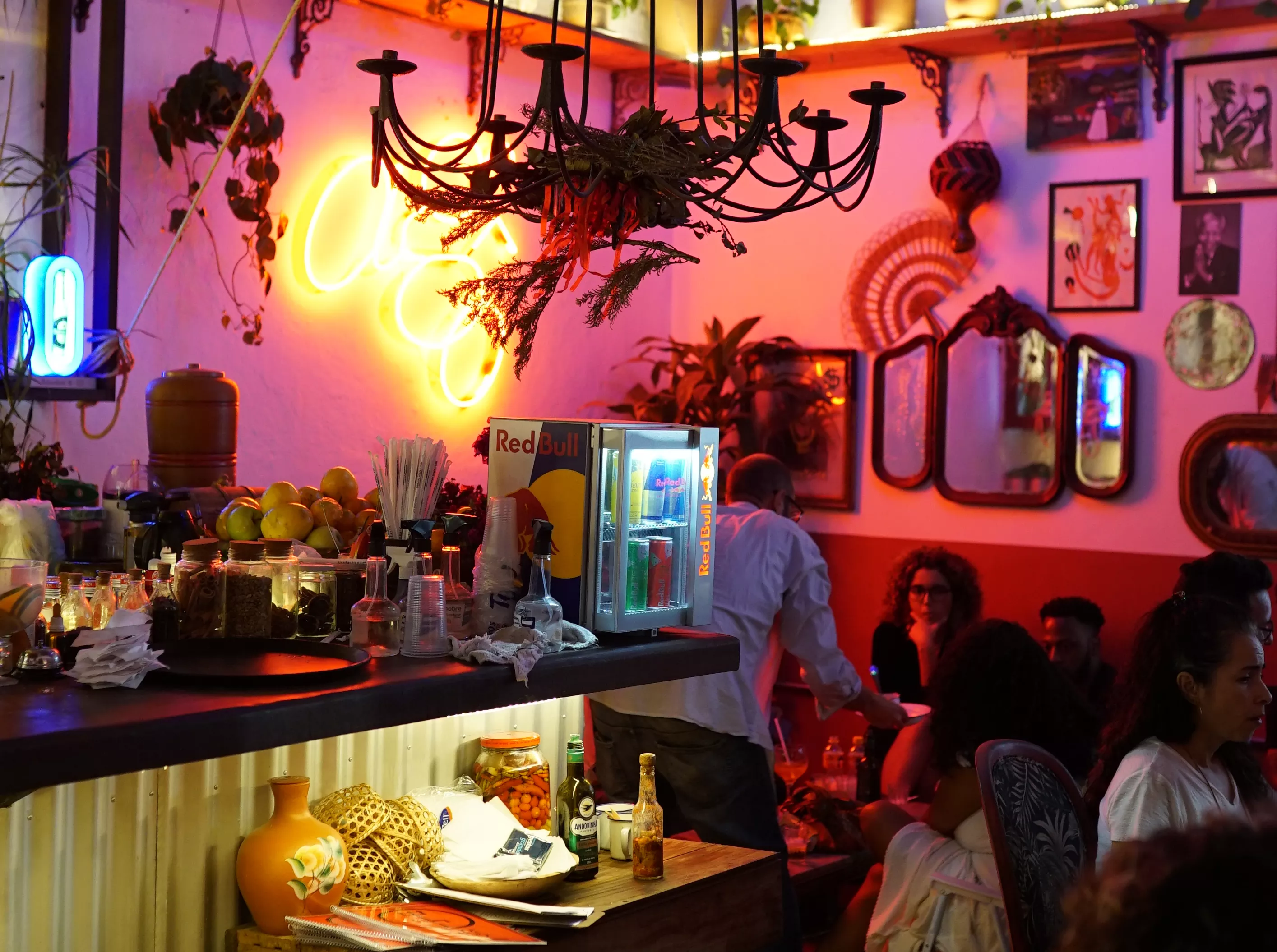Interior do estabelecimento gastronômico Agô Bar da Encruza. Ambiente com bar e mesas para clientes.