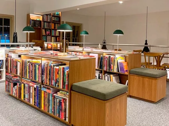 Interior do estabelecimento Livraria Taverna. Ambiente amplo com mostruário de produtos.