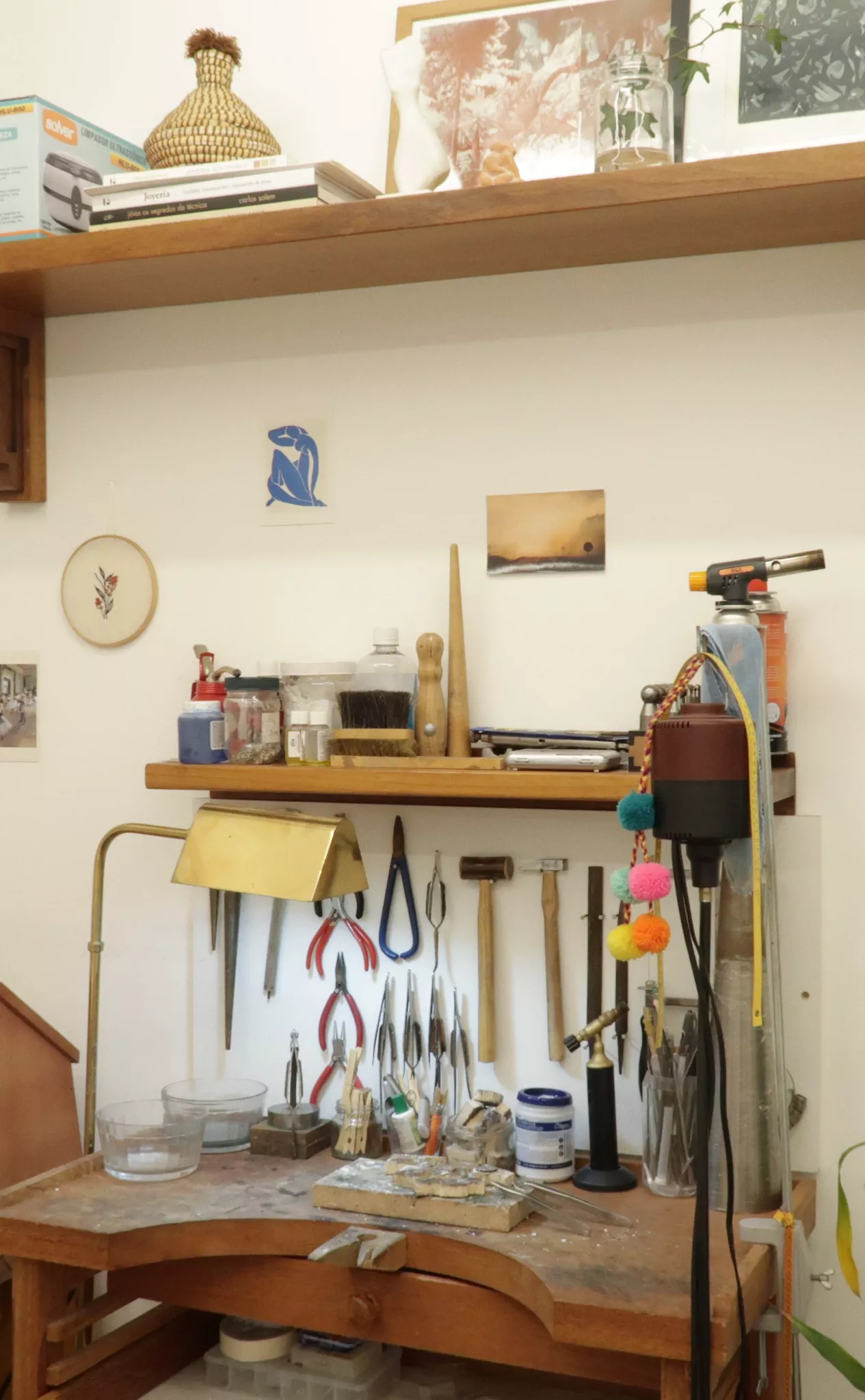 Interior do estabelecimento Demgo. Atelier com ferramentas, mesa de trabalho e equipamentos.
