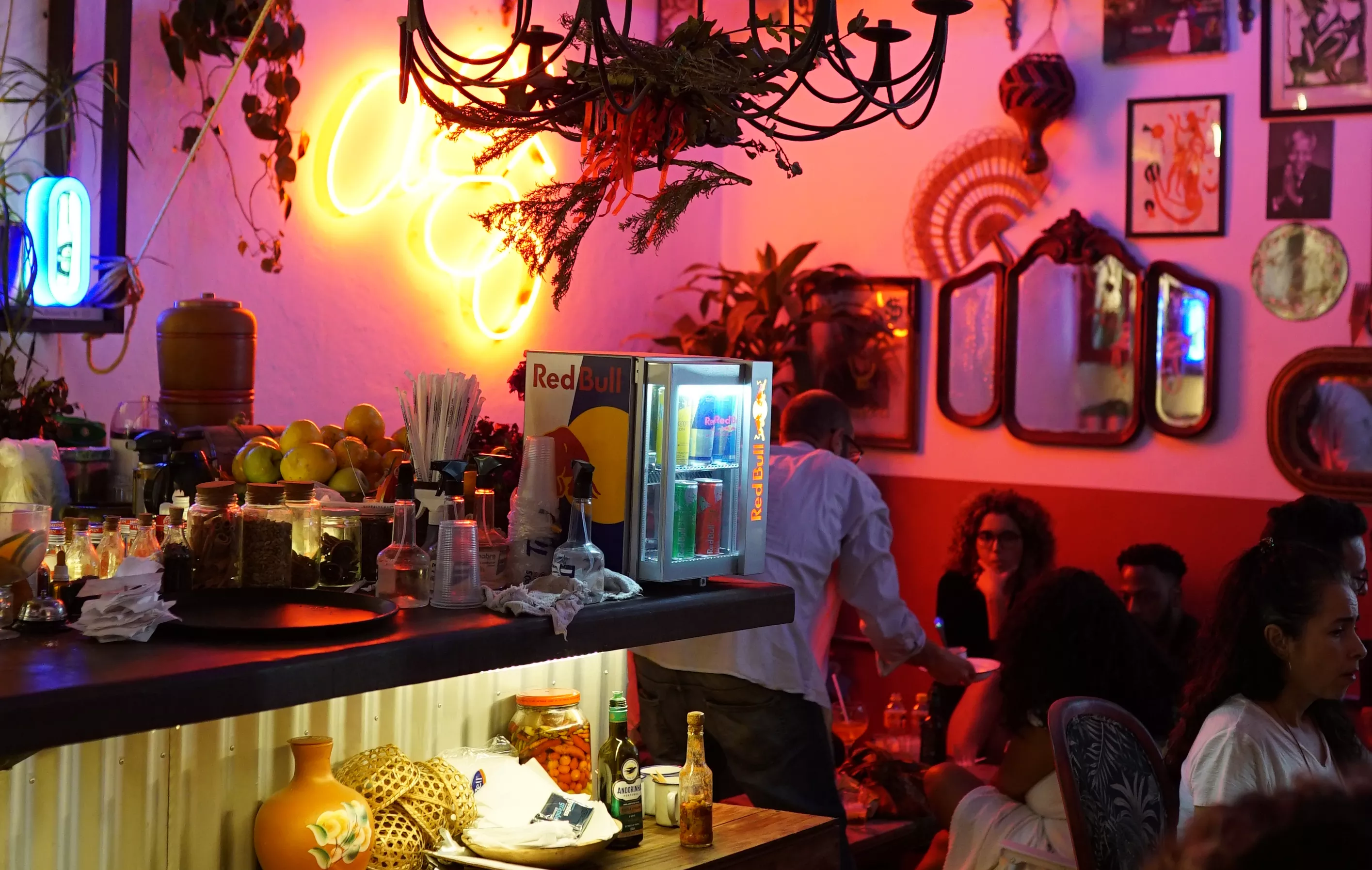 Interior do estabelecimento gastronômico Agô Bar da Encruza. Ambiente com bar e mesas para clientes.